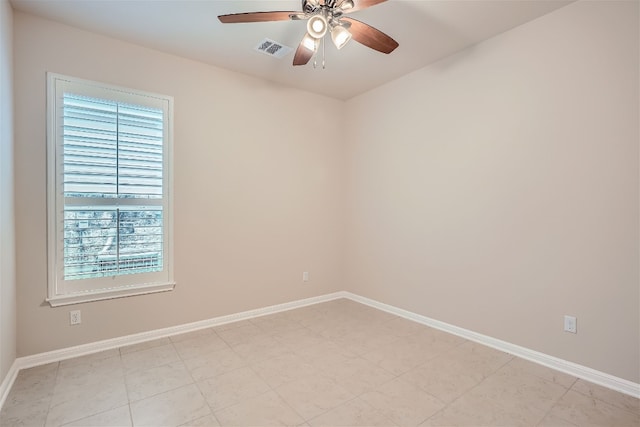 tiled spare room with ceiling fan