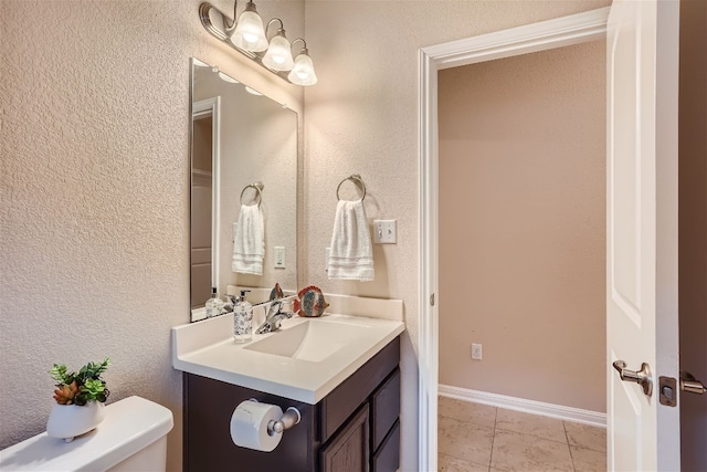 bathroom featuring vanity with extensive cabinet space, toilet, and tile floors