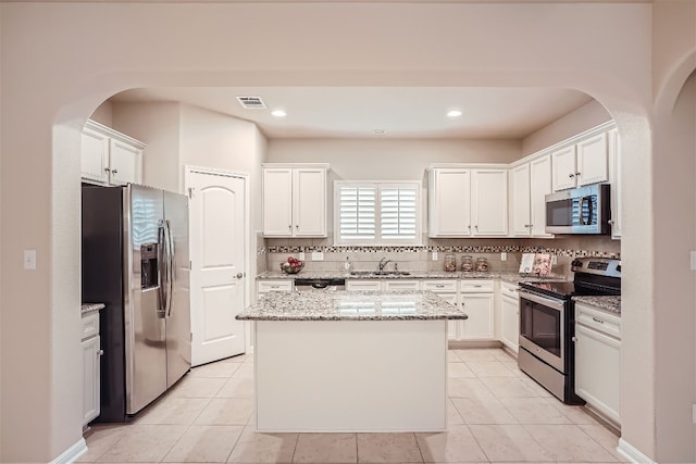 kitchen featuring appliances with stainless steel finishes, white cabinets, and light tile floors