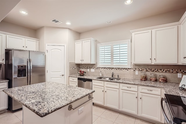 kitchen with backsplash, a center island, and light tile floors