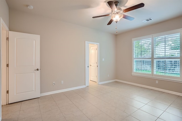 tiled empty room with ceiling fan