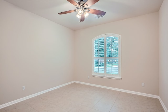 tiled spare room featuring ceiling fan