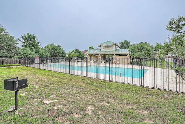 view of swimming pool with a yard