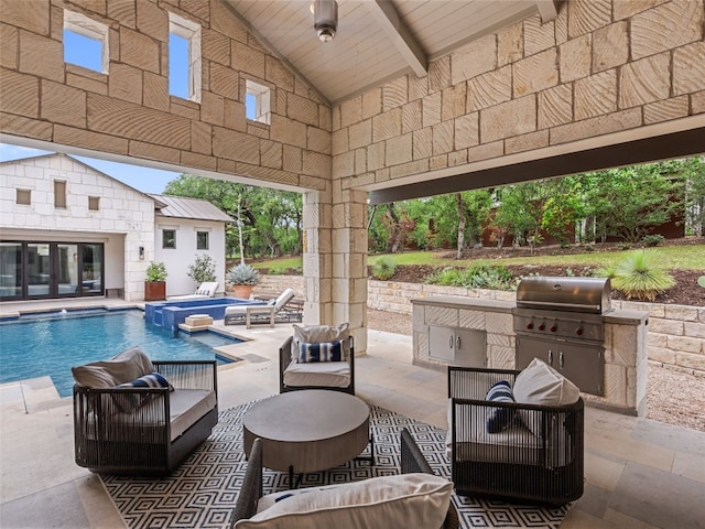 view of pool featuring a patio area, a grill, and an outdoor kitchen