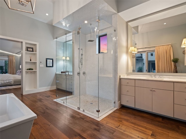 bathroom with hardwood / wood-style flooring, vanity, and independent shower and bath