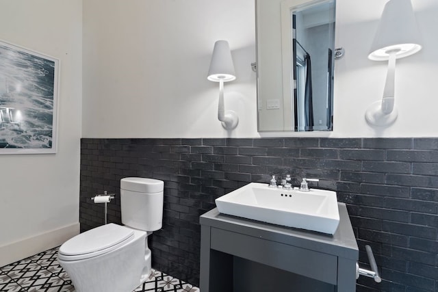 bathroom featuring tile flooring, vanity with extensive cabinet space, tile walls, tasteful backsplash, and toilet