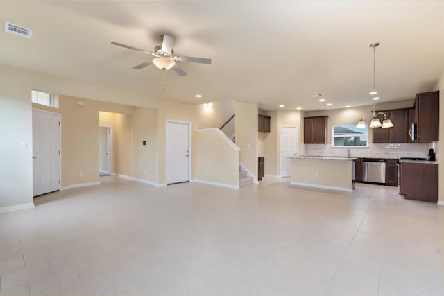 unfurnished living room featuring sink, ceiling fan, and light tile patterned flooring