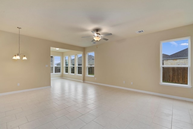 unfurnished room featuring ceiling fan with notable chandelier and light tile patterned floors