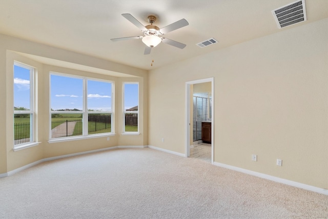 empty room featuring ceiling fan and light carpet