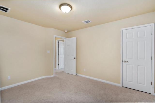 spare room featuring light colored carpet