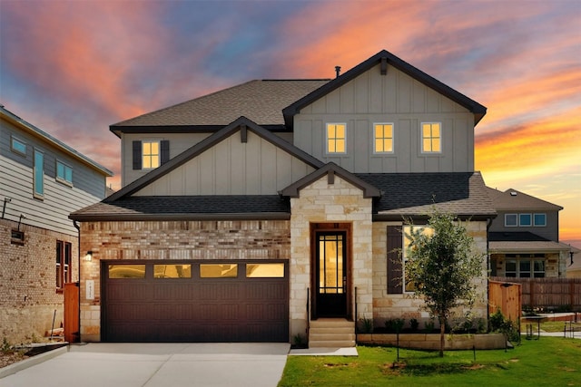 view of front of home with a garage and a lawn