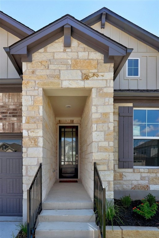 entrance to property with board and batten siding and stone siding