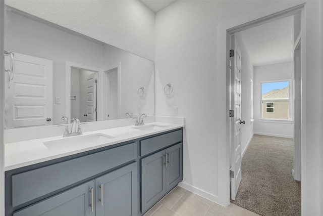 bathroom with double vanity, baseboards, and a sink