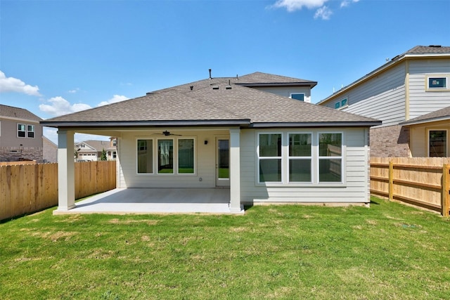 back of property with a ceiling fan, a patio, a fenced backyard, roof with shingles, and a yard