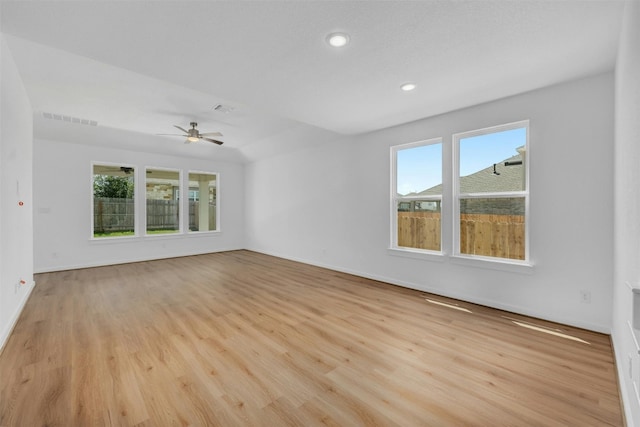 unfurnished room featuring light wood-type flooring, plenty of natural light, visible vents, and baseboards