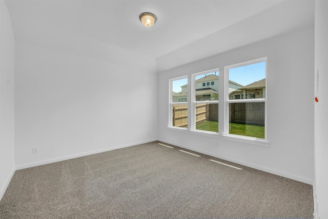 unfurnished room featuring carpet and baseboards