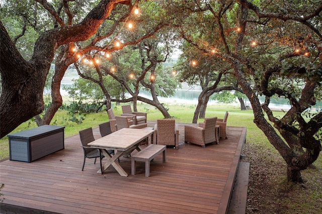 wooden terrace featuring a water view and a lawn