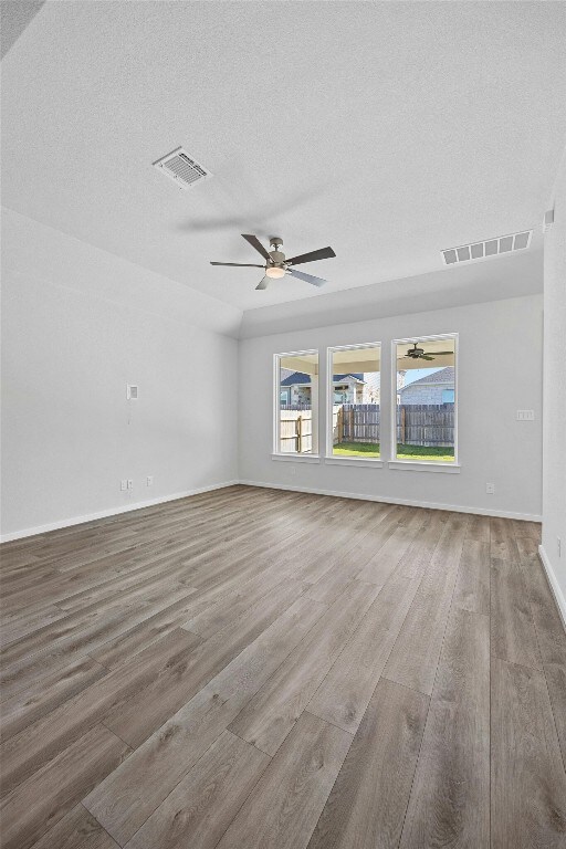 unfurnished living room with ceiling fan, a textured ceiling, and hardwood / wood-style floors