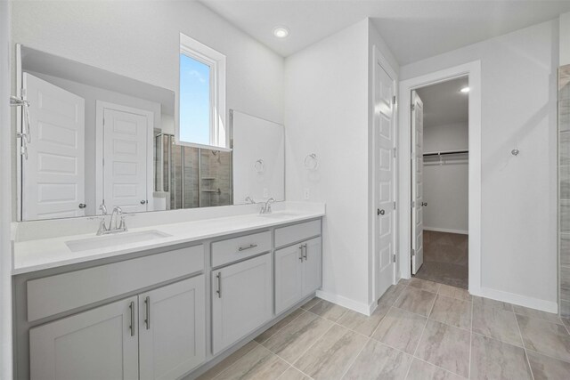 bathroom with tile patterned floors, walk in shower, and vanity