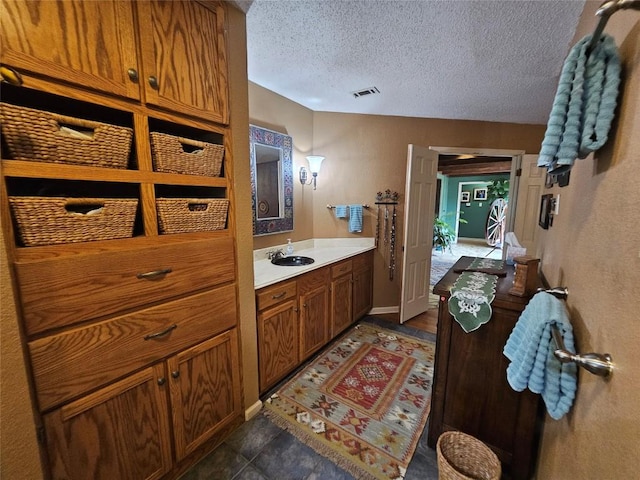 bathroom featuring vanity, a textured ceiling, and tile patterned flooring