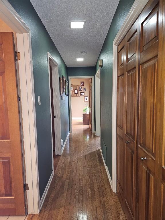 hallway featuring hardwood / wood-style floors and a textured ceiling