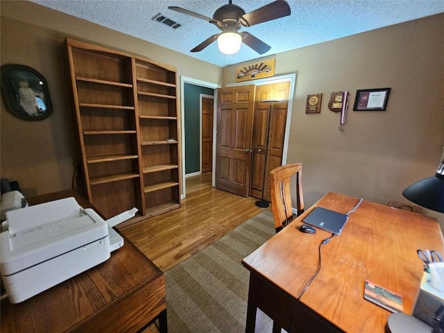 office space with hardwood / wood-style flooring, ceiling fan, and a textured ceiling