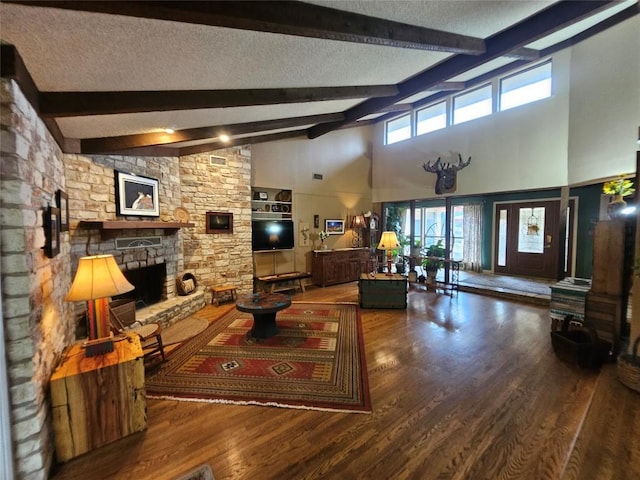 living room featuring high vaulted ceiling, a fireplace, a textured ceiling, beamed ceiling, and wood-type flooring