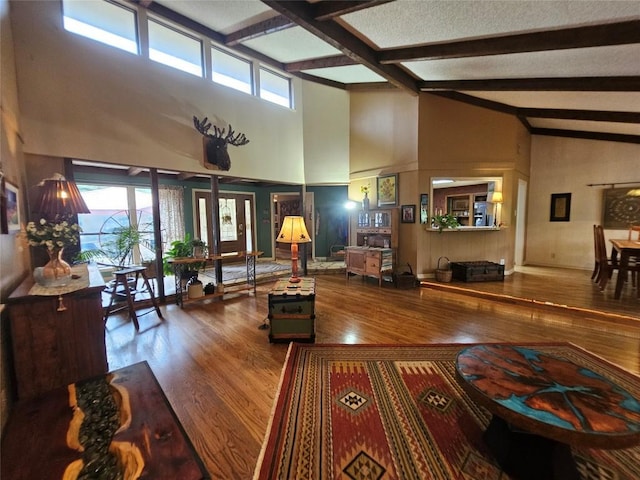 living room with hardwood / wood-style floors, high vaulted ceiling, and beam ceiling