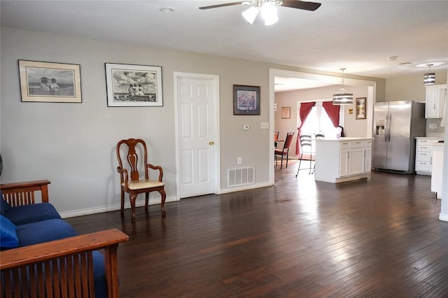 living room with dark wood-type flooring and ceiling fan