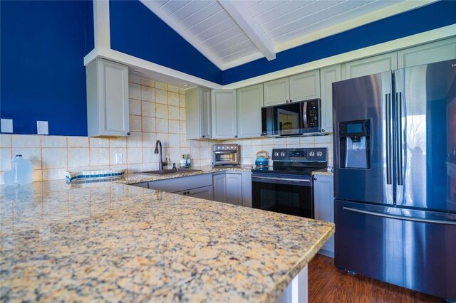 kitchen featuring beamed ceiling, stainless steel appliances, backsplash, light stone countertops, and dark hardwood / wood-style flooring