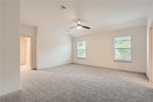 unfurnished room featuring light carpet, a wealth of natural light, and ceiling fan