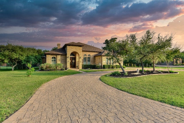 mediterranean / spanish house featuring a lawn