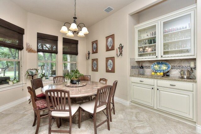 tiled dining area featuring a chandelier