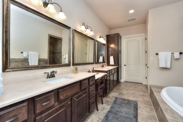 bathroom featuring large vanity, tile floors, dual sinks, and tiled tub