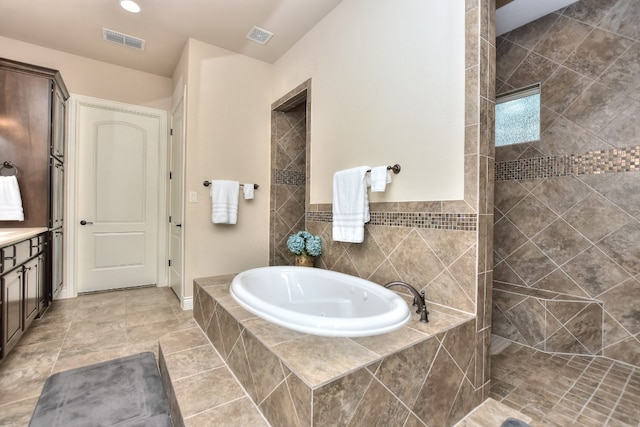 bathroom with tile walls, plus walk in shower, vanity, and tile floors