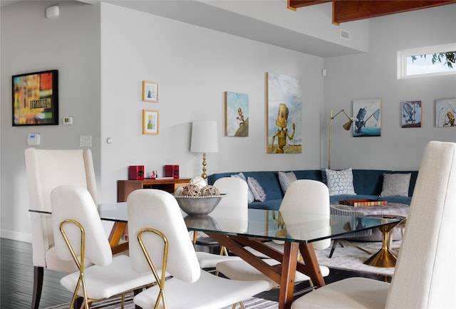 dining space featuring wood-type flooring and beam ceiling