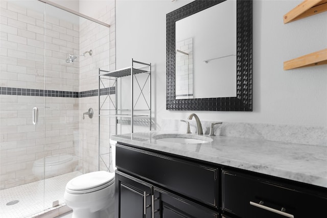 bathroom with a shower with door, vanity, and toilet