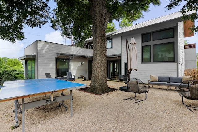 rear view of property featuring an outdoor living space and a patio