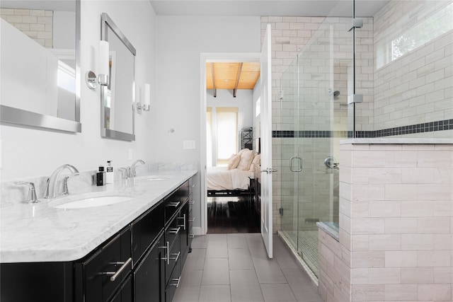 bathroom with oversized vanity, a shower with shower door, dual sinks, and tile flooring