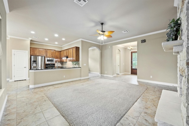 living room featuring ceiling fan with notable chandelier, crown molding, sink, light tile patterned floors, and a stone fireplace