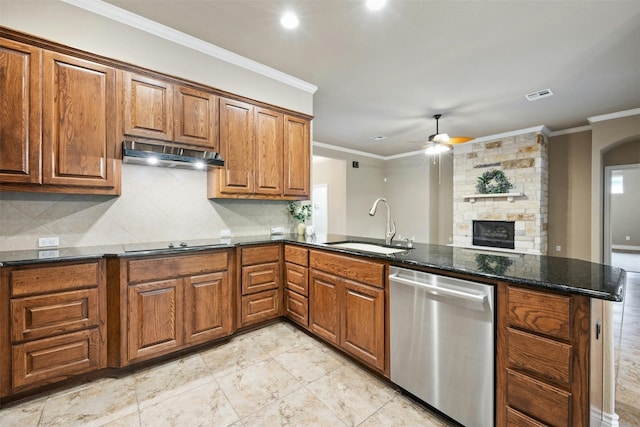 kitchen with kitchen peninsula, ornamental molding, dark stone counters, dishwasher, and a stone fireplace