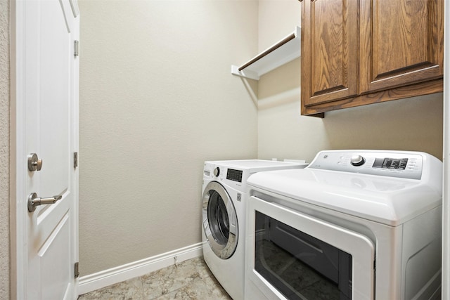 washroom with washer and clothes dryer and cabinets