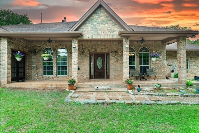 view of front of home with a yard and ceiling fan