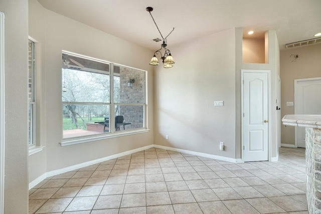 unfurnished room featuring an inviting chandelier and light tile floors