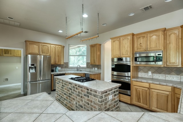 kitchen with backsplash, stainless steel appliances, sink, and light tile flooring