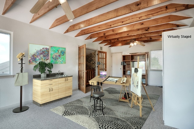 dining space with beamed ceiling, ceiling fan, a healthy amount of sunlight, and carpet flooring