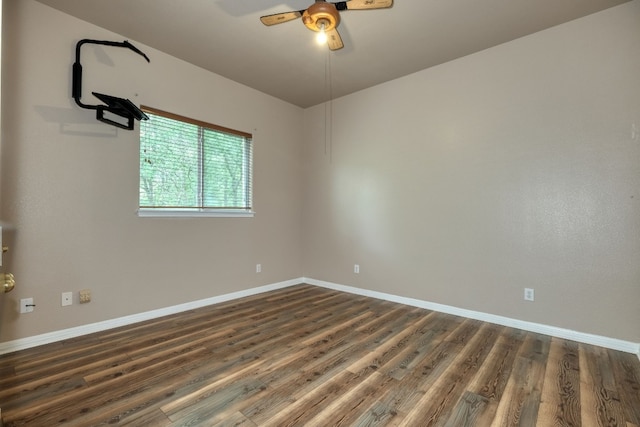 empty room with ceiling fan and dark hardwood / wood-style flooring