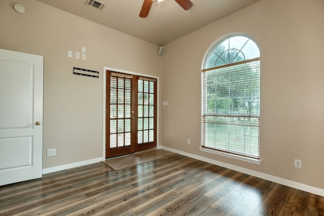 unfurnished room featuring a wealth of natural light and dark wood-type flooring