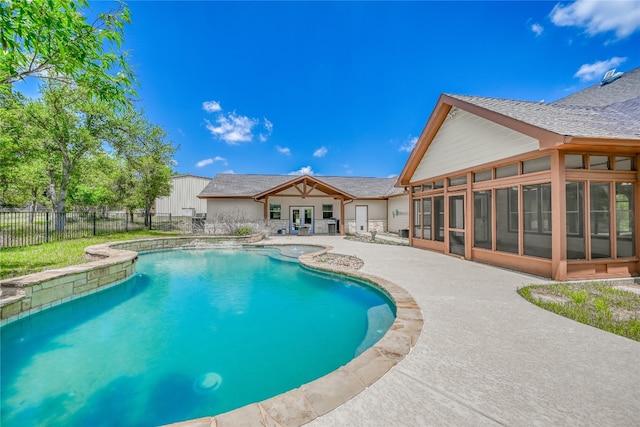 view of swimming pool with a sunroom and a patio