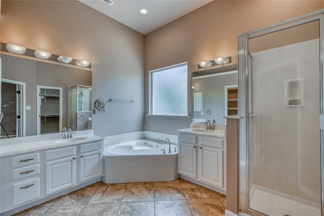 bathroom featuring oversized vanity, tile floors, double sink, and separate shower and tub